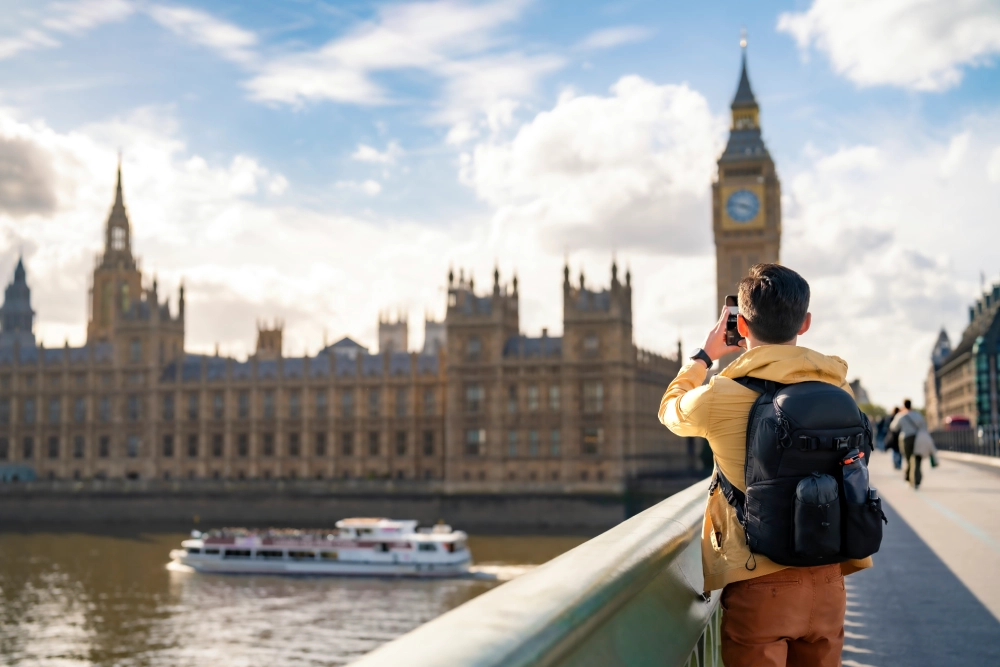 A man taking a picture of big ben in london.