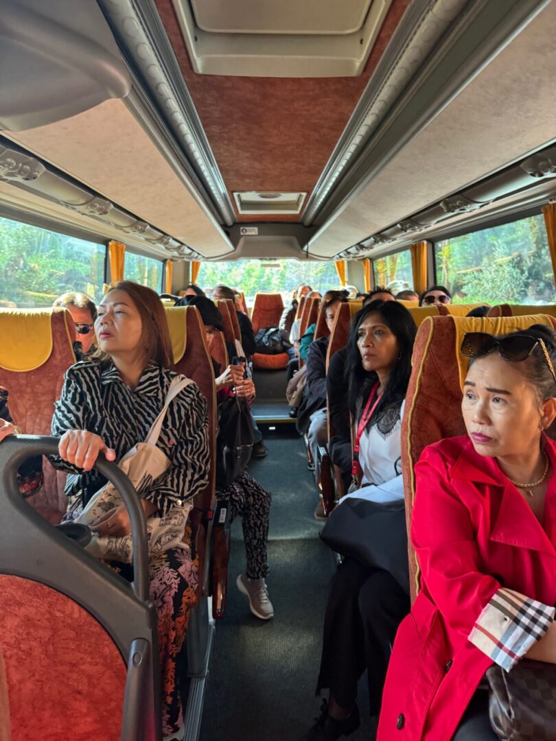 A group of people riding on the back of a bus.