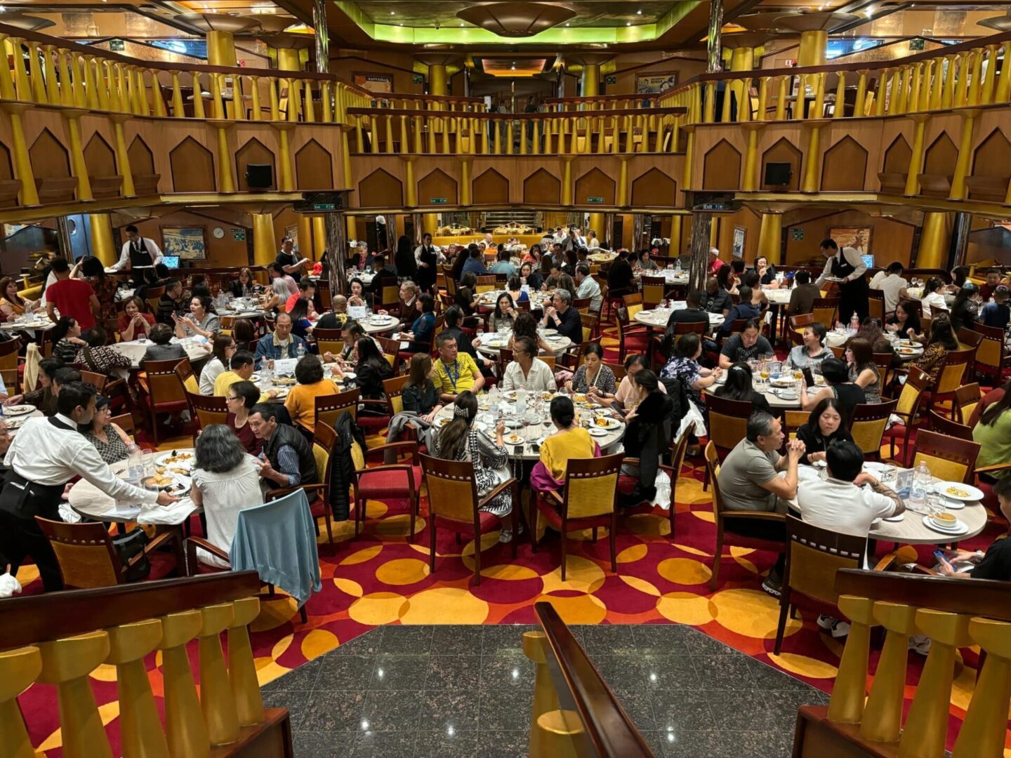 A large group of people sitting at tables in a restaurant.