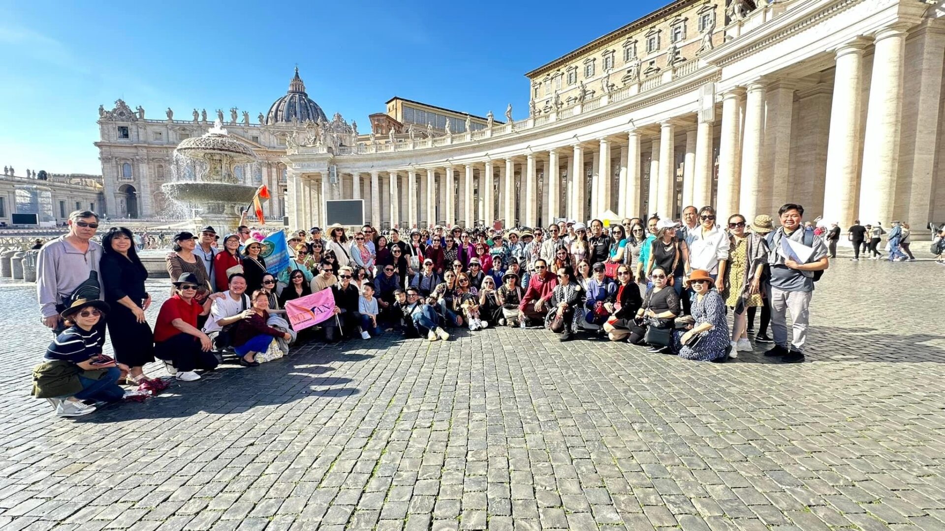 A group of people sitting in front of a building.