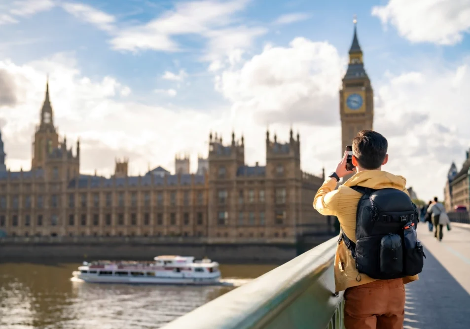 A man taking a picture of big ben in london.